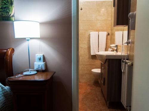 a bathroom with a sink and a lamp on a table at Torre di Renda in Piazza Armerina