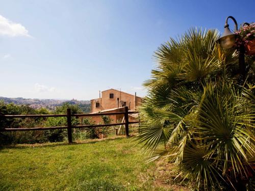 a fence with a palm tree next to a building at Torre di Renda in Piazza Armerina