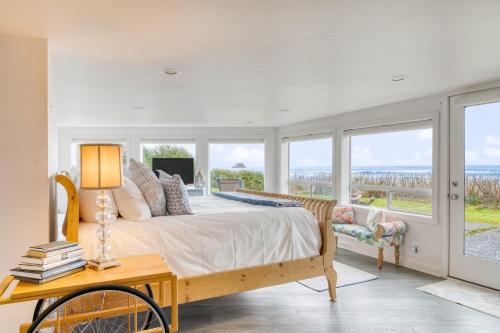 a bedroom with a bed and a table and windows at Sanctuary by the Sea by AvantStay Waterfront Views in Arch Cape