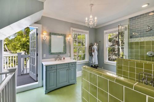 a bathroom with a sink and a shower with green tiles at Lighthouse Villa by AvantStay Walk to Southernmost Point w Private Pool Patio Month Long Stays in Key West