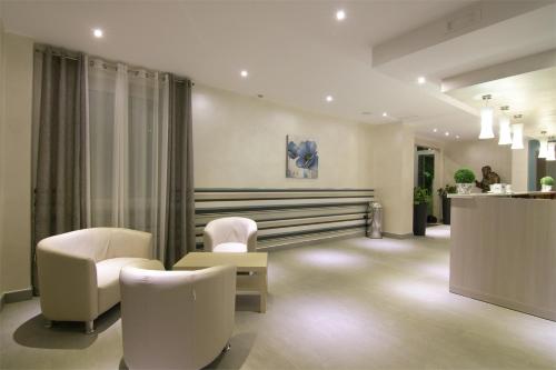 a waiting room with white chairs and a counter at Albergo Villa Bianca in San Giovanni Rotondo