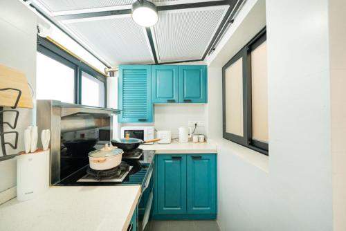 a kitchen with blue cabinets and a stove at Tonight Homestay West Nanjing Road Shanghai in Shanghai