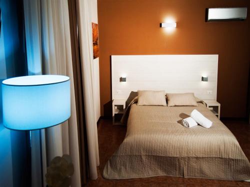 a bedroom with a bed and a blue lamp at Torre di Renda in Piazza Armerina
