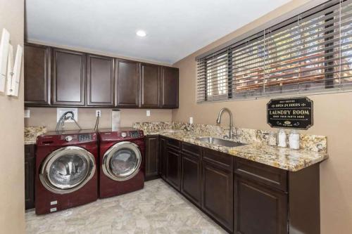 a kitchen with a washer and dryer and a sink at Dawn and Dusk by AvantStay Modern Cabin in Great Location w Home Theatre in Big Bear Lake