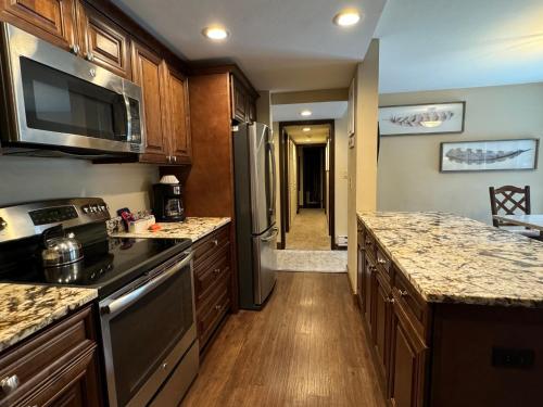 a kitchen with stainless steel appliances and wooden cabinets at The Forest Neighborhood by Keystone Resort in Keystone