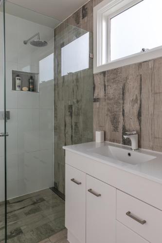 a bathroom with a white sink and a shower at Sandy point hideaway in Sandy Point