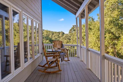 a porch with two rocking chairs and a table at Hidden Oaks Farmhouse by AvantStay Hot Tub Deck in Atascadero