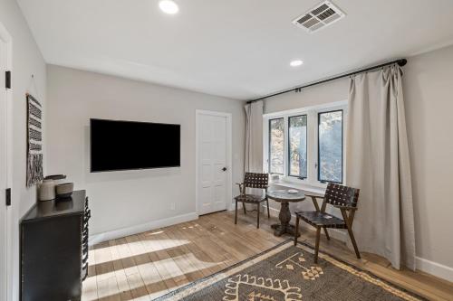a living room with a tv and a table and chairs at Hidden Oaks Farmhouse by AvantStay Hot Tub Deck in Atascadero