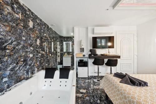 Il comprend un salon avec une baignoire et une cuisine. dans l'établissement Love Room - La Création d'Adam avec Jacuzzi, à Corbeil-Essonnes