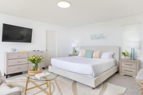 a white bedroom with a bed and a couch at Stardust by AvantStay Views Hot Tub Pool Table in Malibu