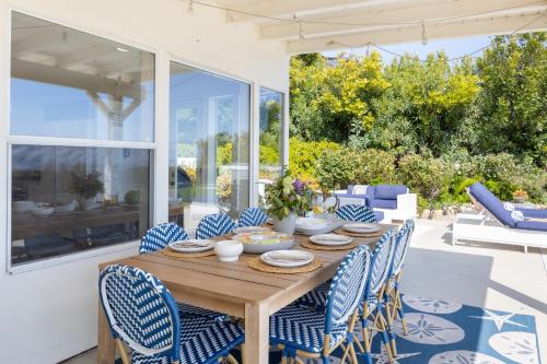 a wooden table with blue and white chairs on a patio at Stardust by AvantStay Views Hot Tub Pool Table in Malibu