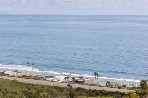 a road next to the ocean with palm trees at Stardust by AvantStay Views Hot Tub Pool Table in Malibu