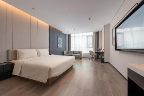 Un dormitorio con una cama grande y un televisor de pantalla plana. en Atour Hotel Guangzhou Baiyun Guanghuayi Road, en Guangzhou