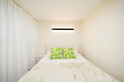 a white bedroom with a bed with a pillow at Tonight Homestay West Nanjing Road Shanghai in Shanghai