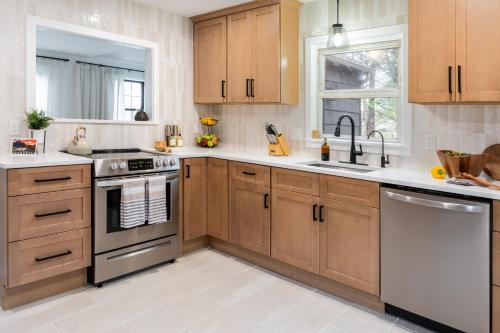 a kitchen with wooden cabinets and stainless steel appliances at Charcoal Chalet by AvantStay A Design w Firepit in New Paltz