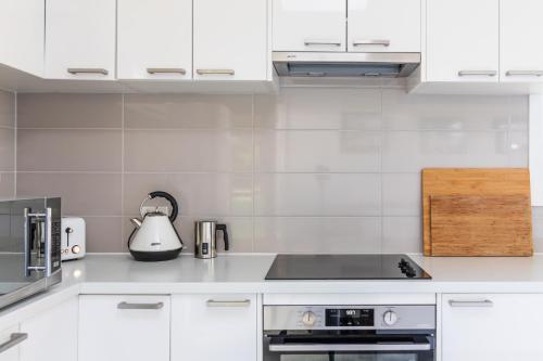 a kitchen with white cabinets and a stove top oven at Sandy point hideaway in Sandy Point
