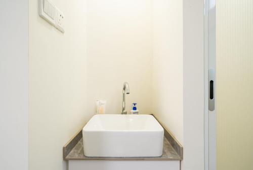 a bathroom with a white sink in a room at Tonight Homestay West Nanjing Road Shanghai in Shanghai