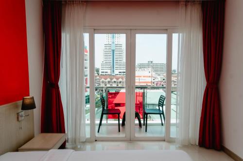 a room with a table and chairs and a balcony at SLEEP WITH ME HOTEL design hotel @ patong (SHA Plus+) in Patong Beach