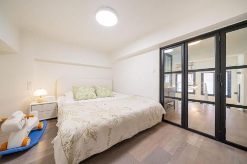 a bedroom with a bed and a large window at Tonight Homestay West Nanjing Road Shanghai in Shanghai