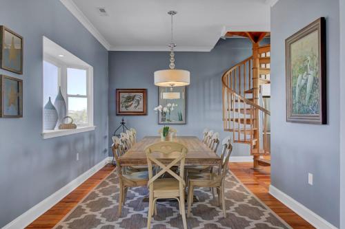 a dining room with a wooden table and chairs at 502 Ocean Blvd by AvantStay Beachfront w Pool Ocean Views in Mount Pleasant
