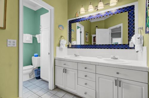 a bathroom with two sinks and a large mirror at 502 Ocean Blvd by AvantStay Beachfront w Pool Ocean Views in Mount Pleasant