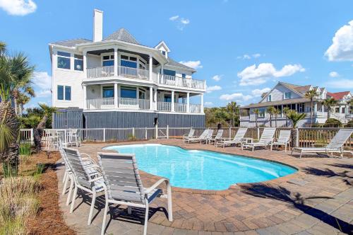a house with a swimming pool and lounge chairs at 502 Ocean Blvd by AvantStay Beachfront w Pool Ocean Views in Mount Pleasant