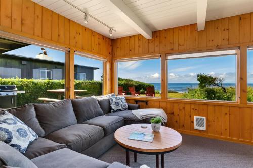 a living room with a couch and a table at The Pilot House by AvantStay Stunning Home Right On Arch Cape Beach in Arch Cape