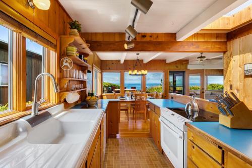 a kitchen with wooden cabinets and blue counter tops at The Pilot House by AvantStay Stunning Home Right On Arch Cape Beach in Arch Cape