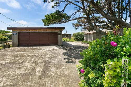a driveway with a garage in front of a house at The Pilot House by AvantStay Stunning Home Right On Arch Cape Beach in Arch Cape