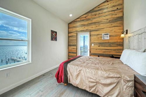 a bedroom with a wooden accent wall and a bed at Waterfront w Bay Views Shared Pool Boat Dock Marlin Madness by AvantStay in Padre Island