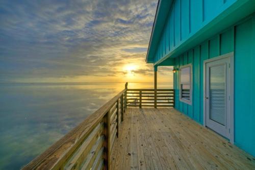 a blue building with a door on the end of a dock at Waterfront w Bay Views Shared Pool Boat Dock Marlin Madness by AvantStay in Padre Island