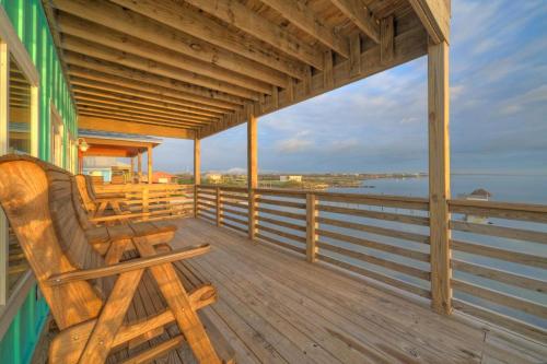 a porch with a bench and a view of the water at Waterfront w Bay Views Shared Pool Boat Dock Marlin Madness by AvantStay in Padre Island