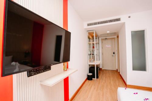a living room with a flat screen tv on a wall at SLEEP WITH ME HOTEL design hotel @ patong (SHA Plus+) in Patong Beach