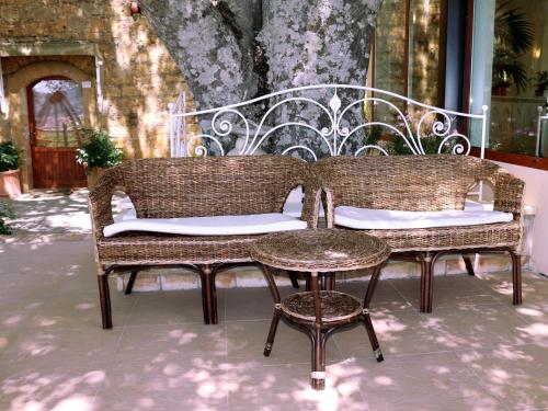 two wicker chairs and a table on a patio at Torre di Renda in Piazza Armerina