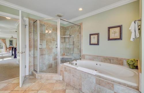 a large bathroom with a tub and a shower at 7 41st Avenue by AvantStay Private Pool Near Beach in Isle of Palms