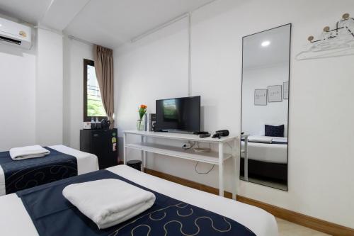 a hotel room with two beds and a television at Nature Boutique Residence in Bangkok