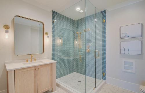 a bathroom with a shower with a sink and a mirror at 710 Ocean Boulevard AvantStay Oceanfront Private Pool Rooftop Deck in Mount Pleasant