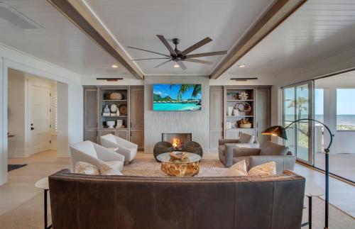 a living room with a ceiling fan and a table at 710 Ocean Boulevard AvantStay Oceanfront Private Pool Rooftop Deck in Mount Pleasant