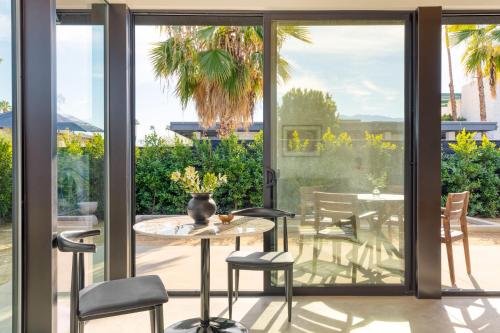a patio with sliding glass doors and a table and chairs at Blackhaus Full Buyout by AvantStay 16-Room Hotel in Palm Springs