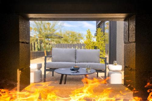 a living room with a couch and a table with flames at Blackhaus Full Buyout by AvantStay 16-Room Hotel in Palm Springs