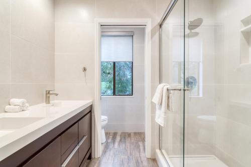 a white bathroom with a sink and a shower at Malvasia by AvantStay Luxe Wine Country Retreat in Santa Rosa