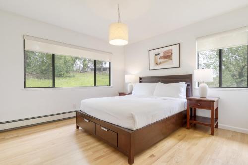 a bedroom with a large bed and two windows at Malvasia by AvantStay Luxe Wine Country Retreat in Santa Rosa