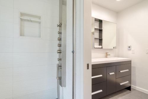 a white bathroom with a sink and a shower at Malvasia by AvantStay Luxe Wine Country Retreat in Santa Rosa