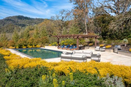 a swimming pool with chairs and a gazebo at Malvasia by AvantStay Luxe Wine Country Retreat in Santa Rosa