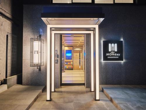a hallway leading into a building with a sign at MONday Apart Premium HAMAMATSUCHO in Tokyo