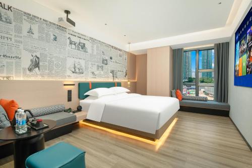 a hotel room with a bed and a desk at Lan Wan Hotel - Next to Huangsha Metro St ation -One cup of Free Cockt ail or Harbin Beer Per Room--Cha rgeable Airport Pick-up Service in Guangzhou