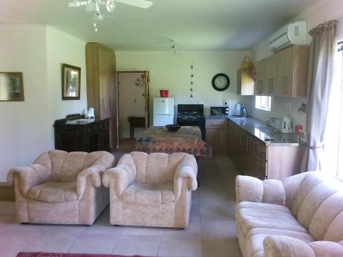 uma sala de estar com dois sofás e uma cozinha em Beaconsfield Farm em Hofmeyr