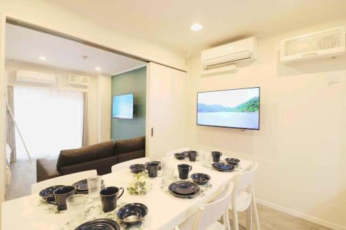a white table in a room with a tv on the wall at Shin Osaka Grand Heights SG51 in Osaka