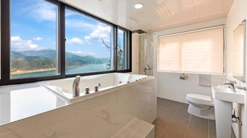 a bathroom with a tub and a toilet and a window at Gapyeong Rondavill Pension in Gapyeong