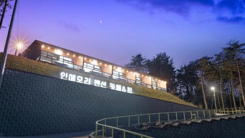 a building with lights on top of a brick wall at Yangyang In Memory Pension in Yangyang